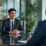 Recibes el correo que tanto esperabas: "Hola, nos gustó mucho tu perfil. Pasaste la entrevista con Recursos Humanos. Queremos invitarte a una prueba técnica la próxima semana". En lugar de saltar de alegría, sientes que el estómago se te hace un nudo. Aparece el temido "Síndrome del Impostor". Empiezas a pensar: "Me van a pedir que hackee la NASA", "Se van a dar cuenta de que busco todo en Google", "No me acuerdo cómo invertir un array de memoria". Tranquilo, respira. Si estás buscando tu primer empleo como Programador Junior (ya sea Frontend, Backend o Full Stack) en una agencia o empresa de software en Paraguay, debes saber un secreto a voces de la industria: nadie espera que un Junior sepa hacerlo todo. Las empresas no buscan una enciclopedia humana que recite código de memoria; buscan a alguien con capacidad analítica, que sepa pedir ayuda y que no se rinda ante un error rojo en la pantalla. Hoy vamos a desmitificar la prueba técnica IT. Te explicaremos exactamente a qué te vas a enfrentar, qué buscan realmente los líderes técnicos (Tech Leads) y cómo debes comportarte para conseguir ese puesto, incluso si tu código no es perfecto. 1. El gran error del Junior: Creer que se evalúa la memoria El sistema educativo tradicional nos enseñó que en un examen no se puede mirar el libro. En la programación profesional, "mirar el libro" (Google, StackOverflow, la documentación oficial) es tu trabajo de todos los días. Cuando un evaluador técnico te pone un problema enfrente, no está evaluando tu memoria sintáctica. Está evaluando tu proceso de pensamiento. Si te piden que crees una función y te olvidas de si el comando llevaba paréntesis o corchetes, no estás desaprobado. Lo que te desaprueba es quedarte callado mirando la pantalla en blanco durante diez minutos sin decir una palabra. El talento más grande de un programador Junior es saber decir: "No recuerdo la sintaxis exacta de esta función, pero la lógica que quiero aplicar es esta... ¿puedo buscar en la documentación cómo se escribe?". El 99% de los evaluadores te dirá que sí y sumará puntos por tu honestidad y recursividad. 2. Los 3 formatos clásicos de la Prueba Técnica Dependiendo del tamaño de la empresa a la que apliques, te enfrentarás a uno (o varios) de estos tres escenarios: A. El Proyecto para la casa (Take-Home Challenge) Es el favorito de muchas agencias. Te envían un documento con un problema y te dan entre 48 horas y una semana para resolverlo. Qué te piden: Generalmente es consumir una API pública (ej: una lista de películas o el clima) y mostrarla en una pantalla con un diseño decente. Qué evalúan: Tu capacidad de estructurar un proyecto desde cero, cómo nombras a tus variables (que sean legibles), si usas control de versiones (Git/GitHub) y si tu código está ordenado. El truco: Haz más de lo mínimo indispensable. Si te piden que la lista se vea, agrégale un buscador o un mensaje de error por si el internet se corta. Esos detalles te consiguen el trabajo. B. El "Live Coding" (Programar en vivo) Es el formato que genera más ansiedad. Compartes tu pantalla por Zoom o Google Meet y tienes que resolver un ejercicio algorítmico o armar un componente web mientras uno o dos programadores Senior te miran teclear. Qué evalúan: Cómo manejas la presión y cómo te comunicas. El truco: Piensa en voz alta. Nunca escribas código en silencio. Di: "Bueno, primero voy a crear una variable para guardar este dato. Luego creo un bucle para recorrer la lista...". Si te trabas, el evaluador te dará pistas, pero solo puede ayudarte si sabe lo que estás intentando hacer. C. La entrevista teórica / Pizarra No hay código, solo charla. Te hacen preguntas sobre cómo funciona la tecnología por detrás. Qué te piden: Pueden preguntarte: "¿Qué pasa exactamente desde que escribes www.google.com en el navegador hasta que aparece la página?" o "Explícame la diferencia entre el Frontend y el Backend". Qué evalúan: Tu comprensión real de los fundamentos, más allá de saber usar un lenguaje de moda. 3. Las preguntas técnicas "Trampilla" más comunes Si vas a una entrevista de Desarrollo Web, asegúrate de tener muy claros estos 4 conceptos, porque aparecen en casi todas las pruebas: APIs y Promesas: Debes saber cómo tu código se comunica con un servidor para pedir datos (usando fetch o axios), y entender que el internet no es instantáneo (por eso usamos código asíncrono o promesas). Control de Versiones (Git): "¿Qué haces si hay un conflicto al hacer un 'merge' en Git?". Ninguna empresa programa usando Google Drive. Git es el estándar mundial. Estructuras de Datos: Conocer la diferencia entre un Array (lista) y un Objeto (diccionario), y cómo iterar o buscar datos dentro de ellos usando métodos como .map() o .filter(). Respuestas de Servidor (HTTP Codes): Saber que un error 404 es que algo no existe, un 500 es que el servidor explotó, y un 200 es que todo salió bien. 4. Caso Práctico Real: La actitud lo es todo Imaginemos una entrevista para una Software Factory en Asunción. Hay dos candidatos para el puesto de Junior Frontend, Andrés y Sofía. A ambos les piden que centren un botón en la pantalla usando CSS y que al hacer clic, cambie de color. Andrés empieza a teclear rápido. No logra centrar el botón. Se pone nervioso, empieza a transpirar, borra todo y se queda callado durante 5 minutos. Cuando el tiempo termina, dice: "No me sale". Sofía empieza a teclear. Tampoco logra centrar el botón a la primera. Pero Sofía dice en voz alta: "Estoy intentando usar Flexbox, pero parece que el contenedor principal no está ocupando toda la pantalla. Voy a ponerle un borde rojo para ver qué está pasando". Pone el borde, se da cuenta de su error y lo arregla. Luego, para la función del clic, dice: "Sé que necesito un Event Listener, pero no recuerdo la sintaxis exacta, ¿puedo buscarlo en la documentación de Mozilla?". El líder técnico sonríe y asiente. Ambos tuvieron dificultades técnicas, pero Sofía fue contratada. Demostró que sabe depurar problemas, investigar y comunicarse. Andrés demostró que ante la frustración, se paraliza. 5. Mini-Tutorial: Tu plan de acción a 7 días de la entrevista Si tienes tu primera prueba técnica la próxima semana, deja de leer tutoriales nuevos y enfócate en esto: Repasa tus bases: No intentes aprender un Framework nuevo en 3 días. Asegúrate de entender perfectamente la lógica básica: condicionales (if/else), bucles (for/while) y funciones. Prepara tu portafolio en GitHub: El evaluador entrará a ver tu código antes de la entrevista. Asegúrate de tener al menos 2 proyectos fijados con un archivo README.md que explique qué hace el proyecto y qué tecnologías usaste. Un proyecto bien documentado te da autoridad. Practica el "Hablar y Tipear": Siéntate frente a tu computadora, abre un proyecto viejo y empieza a explicar en voz alta, como si estuvieras en un tutorial de YouTube, qué hace cada línea de tu propio código. Acostumbra a tu cerebro a realizar las dos tareas al mismo tiempo. 6. Preguntas Frecuentes (FAQ) de postulantes IT "Si me piden saber una tecnología que no conozco, ¿miento?" Jamás. En la programación, una mentira se descubre en 30 segundos compartiendo pantalla. Si te preguntan si sabes usar TypeScript y no sabes, responde: "No lo he usado en proyectos reales, pero conozco JavaScript a fondo, entiendo el concepto de tipado fuerte y sé que puedo aprenderlo rápido si el equipo lo necesita". "¿Tengo que saber inglés para pasar la prueba técnica?" En Paraguay, muchas empresas operan 100% en español. Sin embargo, las variables, el código y la documentación técnica de la prueba estarán en inglés. Necesitas un nivel de lectura técnica intermedio. Si logras explicar tu código en inglés hablado, tu salario inicial puede duplicarse, ya que aplicarás a empresas internacionales. ¿Las pruebas incluyen mucha matemática compleja? A menos que apliques para un puesto de Inteligencia Artificial, Ciencia de Datos o desarrollo de motores de videojuegos, la respuesta es no. El 95% del desarrollo web comercial requiere lógica estructurada, no cálculo diferencial. Tu primer empleo empieza antes de la entrevista El miedo a la prueba técnica desaparece cuando sabes que tu conocimiento no está basado en copiar y pegar código, sino en entender verdaderamente cómo funciona la tecnología. Si te sientes inseguro construyendo proyectos desde cero o crees que te falta esa base sólida para enfrentarte a los líderes técnicos del mercado, no improvises. En el Instituto de Diseño y Tecnología (IDT), nuestros cursos y diplomados de Desarrollo Web y Programación no solo te enseñan la teoría. Te enseñamos a pensar como programador, a usar las herramientas reales de la industria (Git, APIs, entornos de desarrollo) y a construir un portafolio de proyectos prácticos que hablarán por ti en cualquier entrevista de trabajo. Deja el miedo atrás y prepárate para conquistar la industria tecnológica.